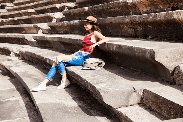 Dziewczyna siedząca na ruinach rzymskiego amfiteatru.
